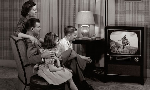 60s family gathered around the television set